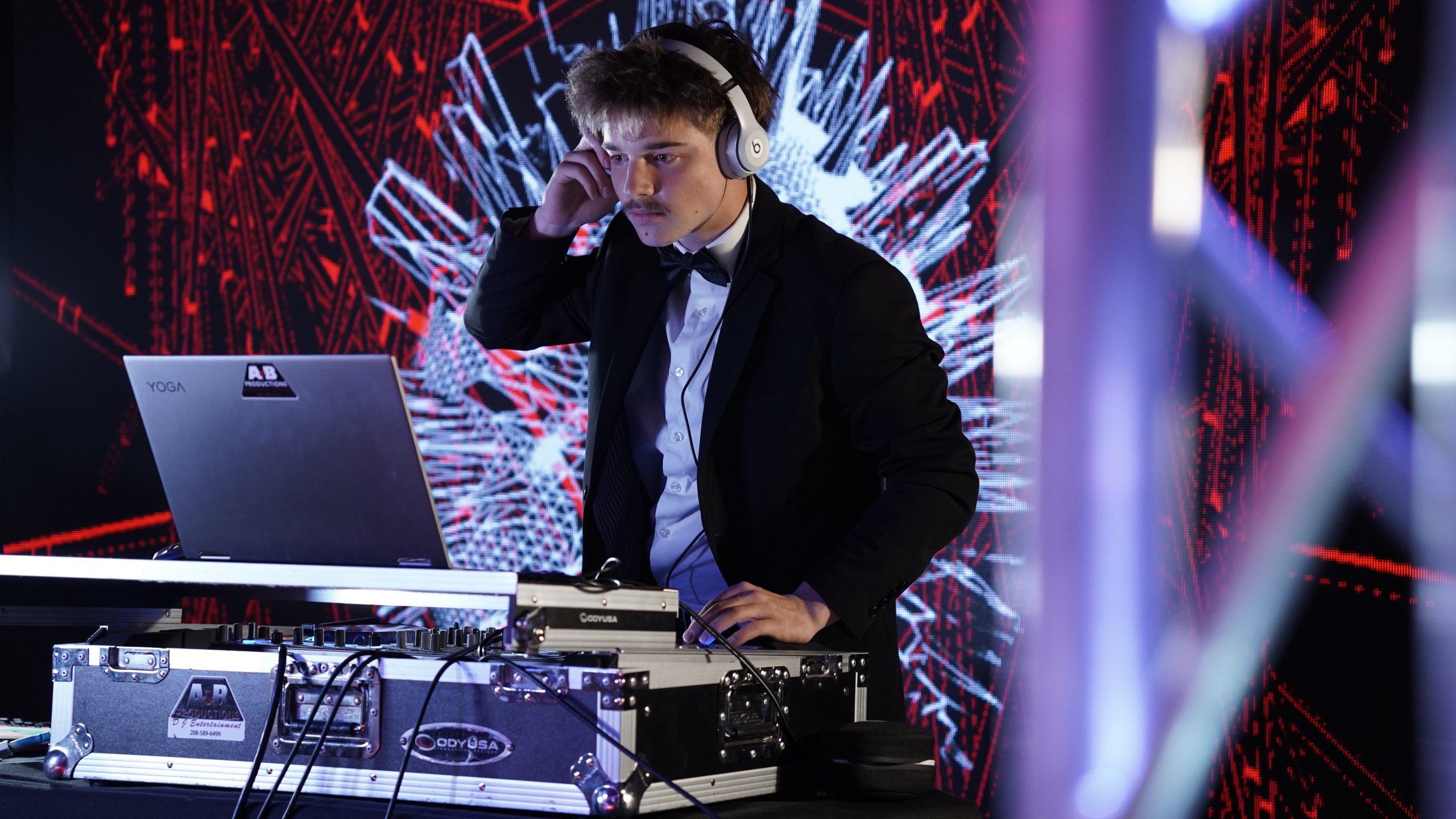 A&B Productions DJ mixing in front of a red laser LED wall