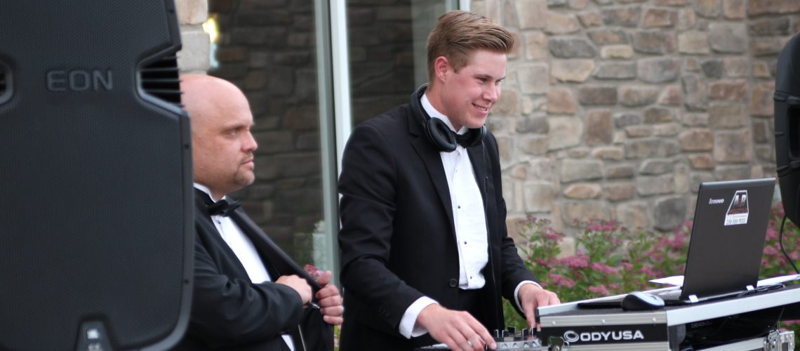 Professional DJ setup by A & B Productions with young DJ at outdoor event.