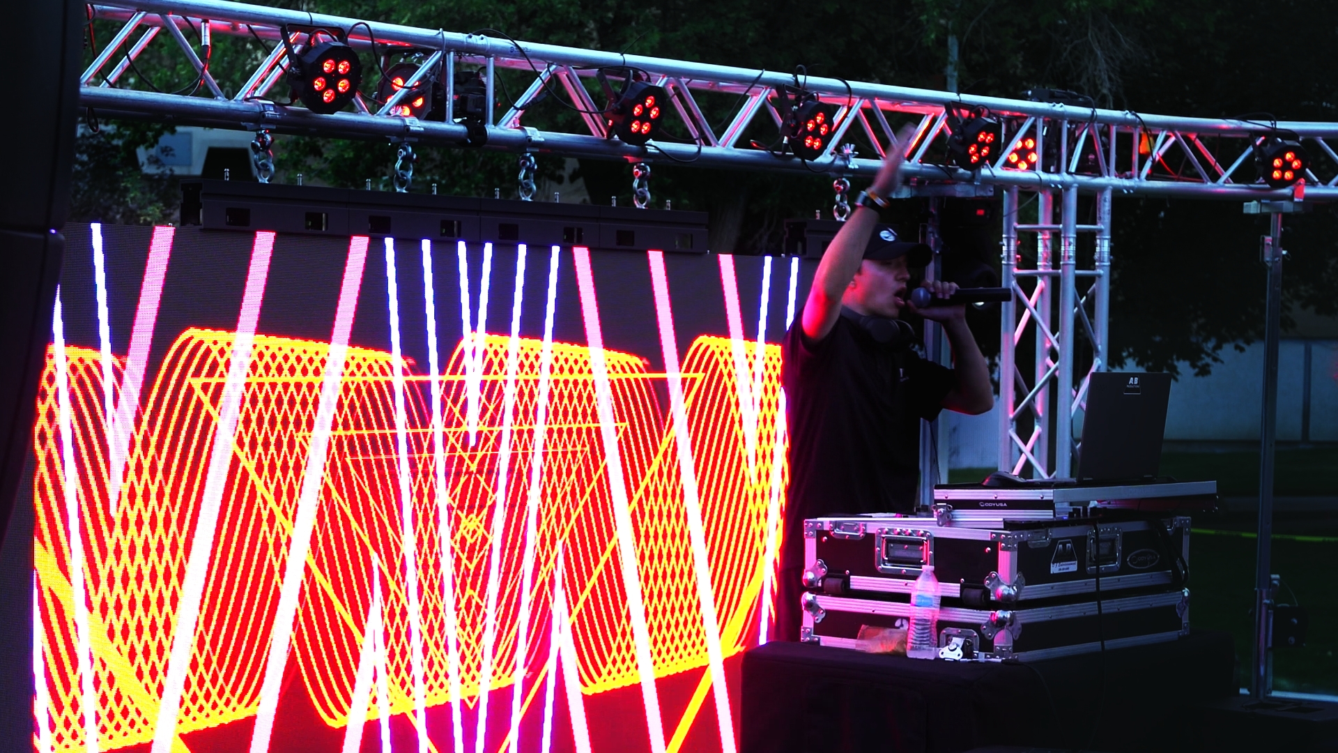 A&B Productions DJ booth with a red LED wall at an outdoor school dance